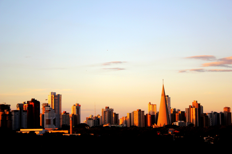 Cidade de Maringá ao pôr do sol, com prédios no horizonte